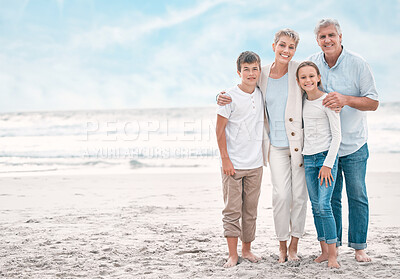 Buy stock photo Shot of a mature couple bonding with their grandchildren at the beach