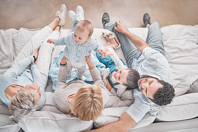 Buy stock photo Bonding, above and big family with a baby for love, care and relax on the living room sofa of a house. Happy parents, girl and senior woman playing with a child on the couch of the family home