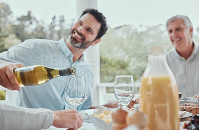 Buy stock photo Shot of a male pouring wine during lunch at home