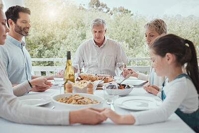 Buy stock photo Shot of a beautiful family blessing the food with a prayer at the table together at home