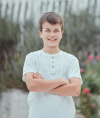 Buy stock photo Shot of a little boy standing with his arms crossed in the garden at home