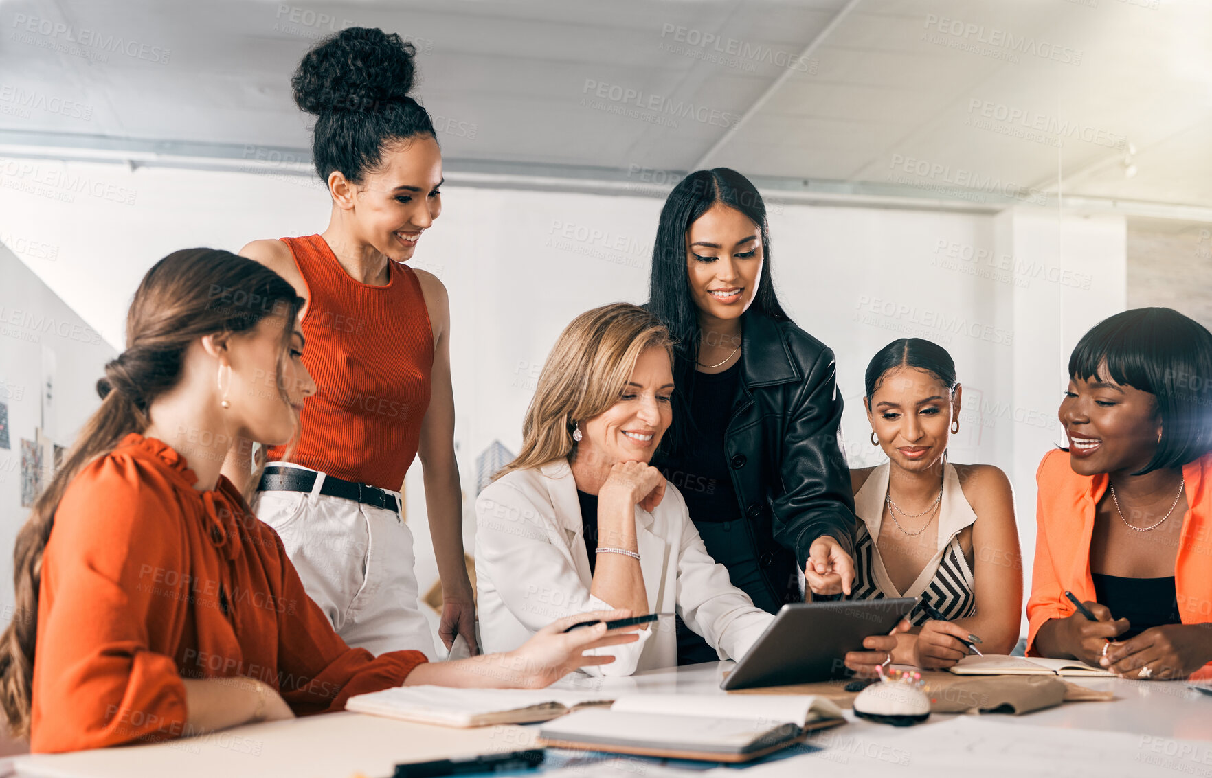 Buy stock photo Shot of a group of businesswomen using a digital tablet together at work