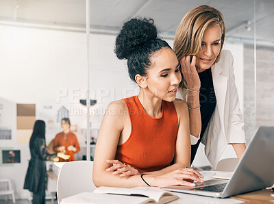 Buy stock photo Shot of a two businesswomen using a laptop together at work