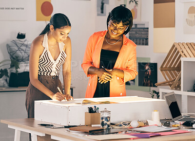 Buy stock photo Shot of two businesswomen working on designs at a workshop