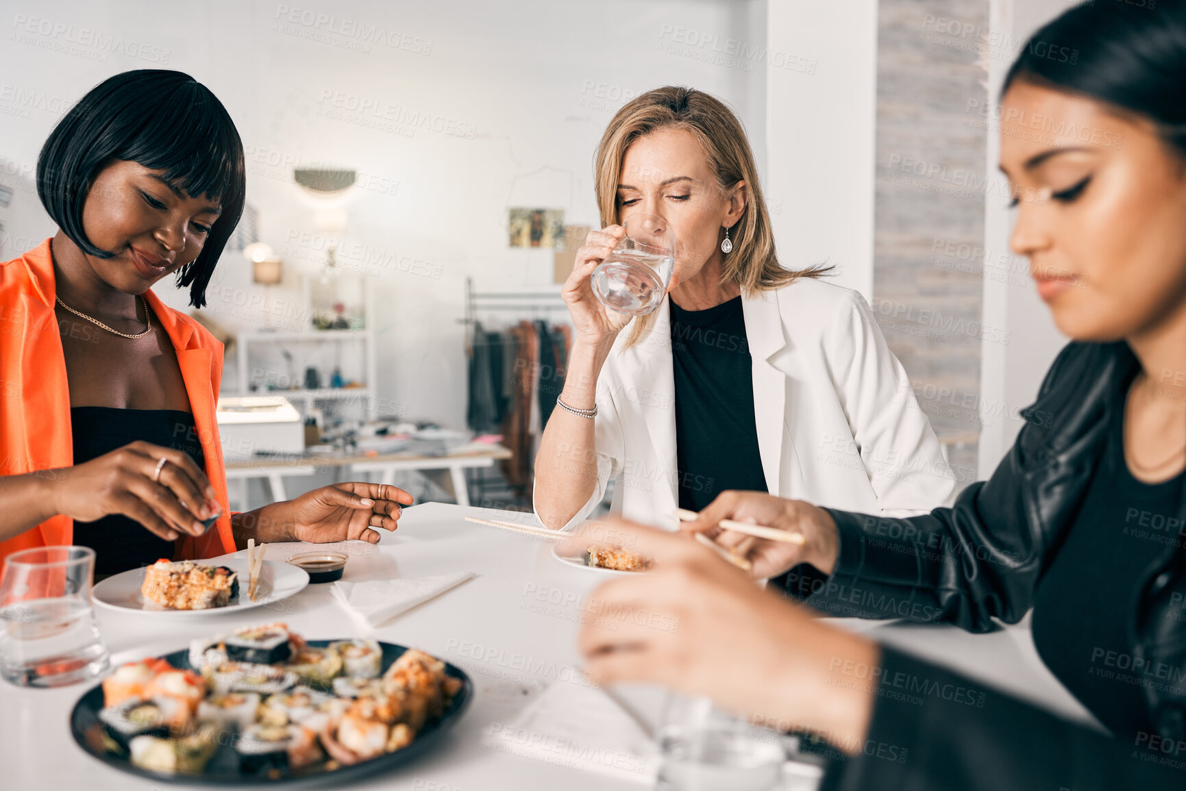 Buy stock photo Sushi, women and relax in office with chopsticks, luxury meal and takeaway food for lunch. Japanese cuisine, utensils and design team at table for sharing, high quality catering and business expense