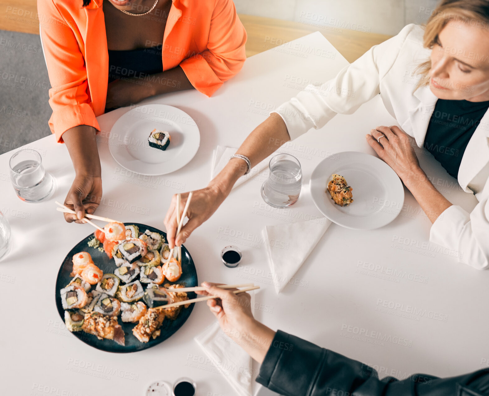 Buy stock photo Above, sushi and women with chopsticks for lunch, luxury meal and takeaway food in office. Japanese cuisine, utensils and friends at table for sharing, high quality catering and business expense