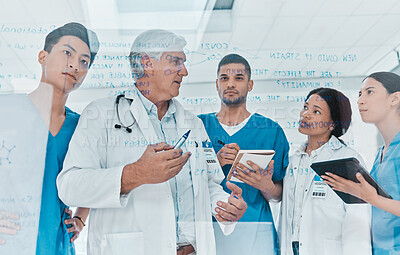 Buy stock photo Shot of a group of medical practitioners brainstorming with notes on a glass wall in a medical office