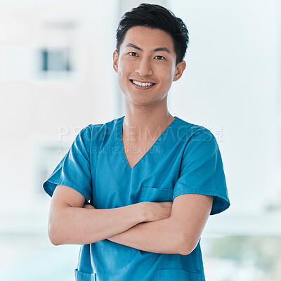 Buy stock photo Portrait of a young doctor standing with his arms crossed in a hospital