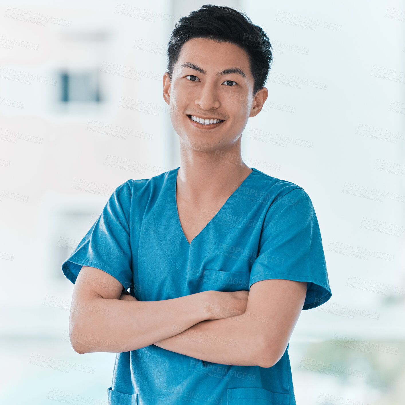 Buy stock photo Portrait of a young doctor standing with his arms crossed in a hospital