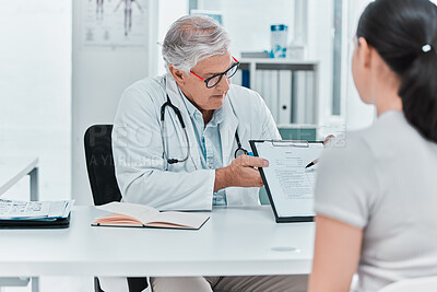 Buy stock photo Shot of a mature doctor sitting with his patient and showing a medical chart during a consultation in his clinic