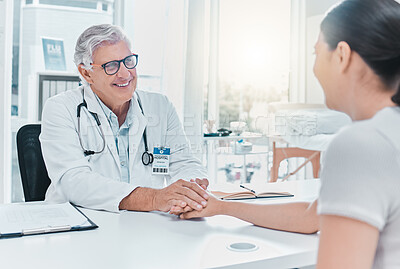 Buy stock photo Shot of a mature doctor sitting with his patient and holding her hand during a consultation in his clinic