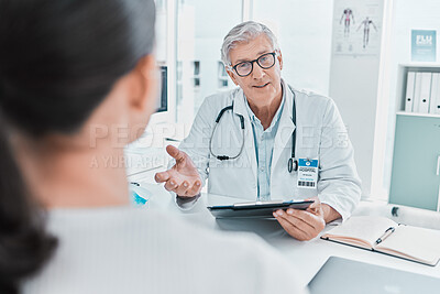 Buy stock photo Shot of a mature doctor sitting with his patient during a consultation in his clinic