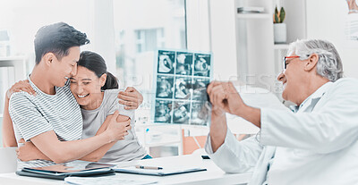 Buy stock photo Shot of a young couple celebrating their pregnancy while sitting with their obstetrician in the clinic