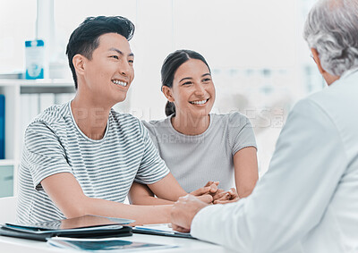 Buy stock photo Shot of a young couple sitting with their doctor during a consultation in the clinic