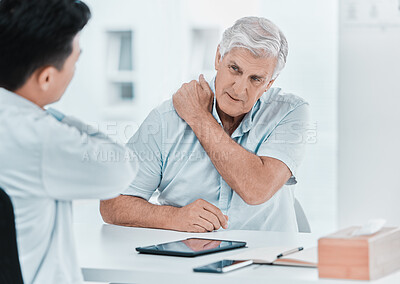 Buy stock photo Shot of a mature man sitting with his doctor and complaining about a sore shoulder during a consultation