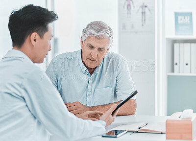 Buy stock photo Shot of a mature man sitting with his doctor and going over his medical results on a digital tablet in the clinic