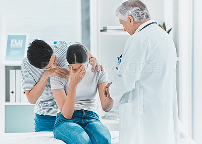Buy stock photo Shot of a young couple receiving bad news from their doctor