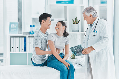 Buy stock photo Shot of a young couple being shown their ultrasounds by their doctor