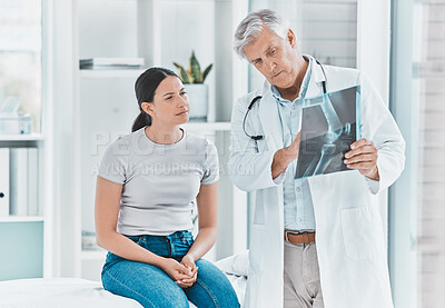 Buy stock photo Shot of a doctor and his patient reviewing their x-ray together