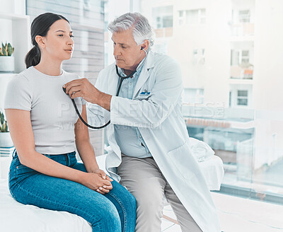 Buy stock photo Shot of a doctor listening to a patients heartbeat using a stethoscope