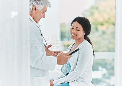 Buy stock photo Shot of a senior doctor reviewing a patients results on a digital tablet