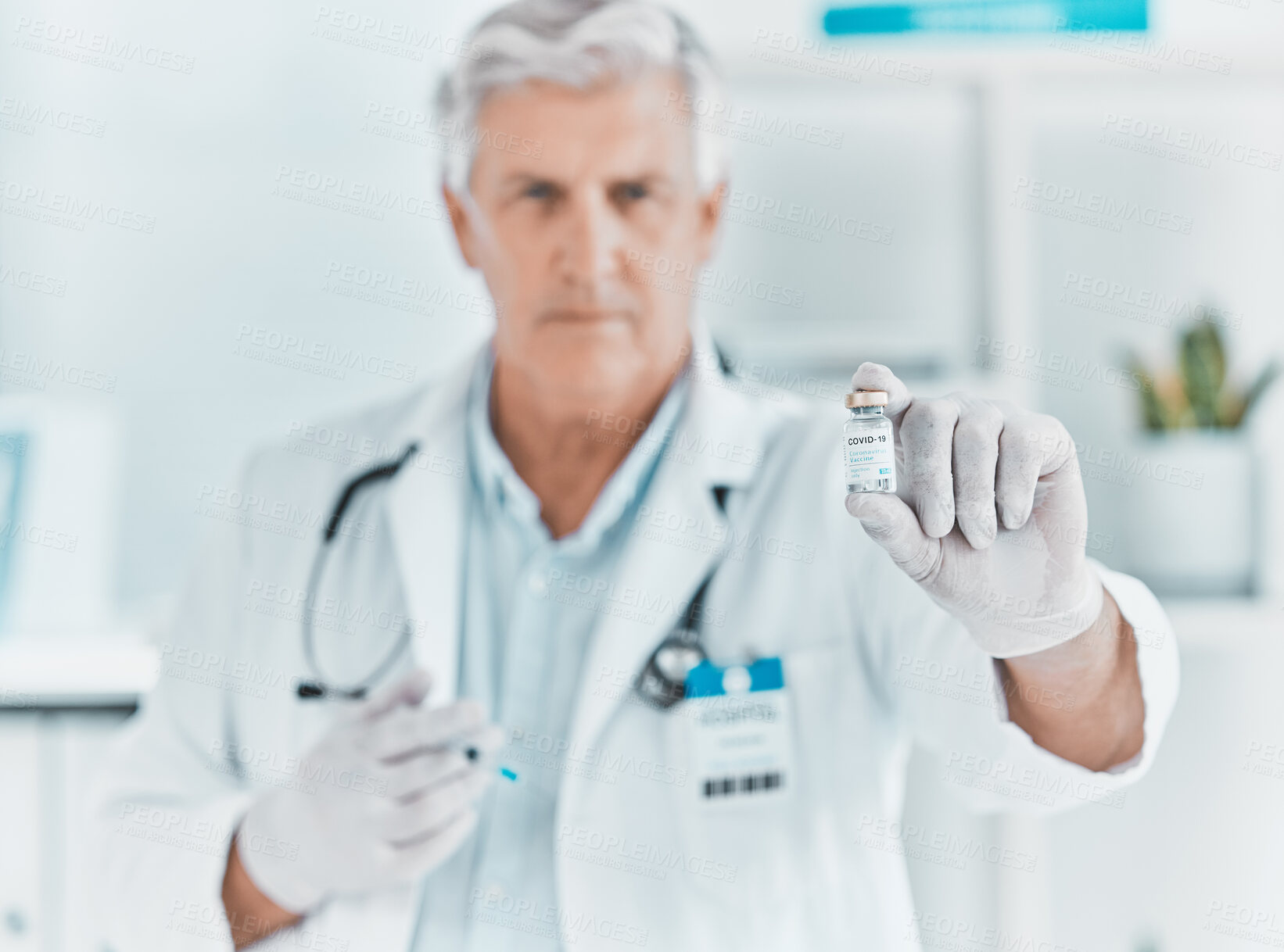 Buy stock photo Shot of a mature doctor holding a vial of the covid vaccine