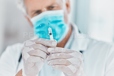 Buy stock photo Shot of a doctor preparing to administer an injection
