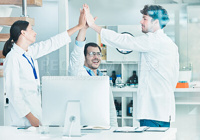 Buy stock photo Shot of a group of young scientists giving each other a high five in a lab
