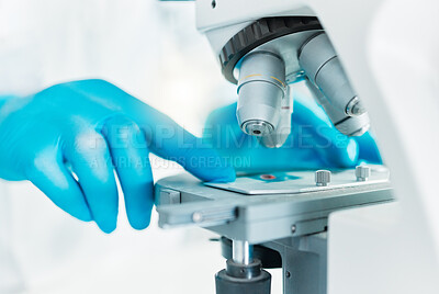Buy stock photo Closeup shot of an unrecognisable scientist using a microscope in a lab