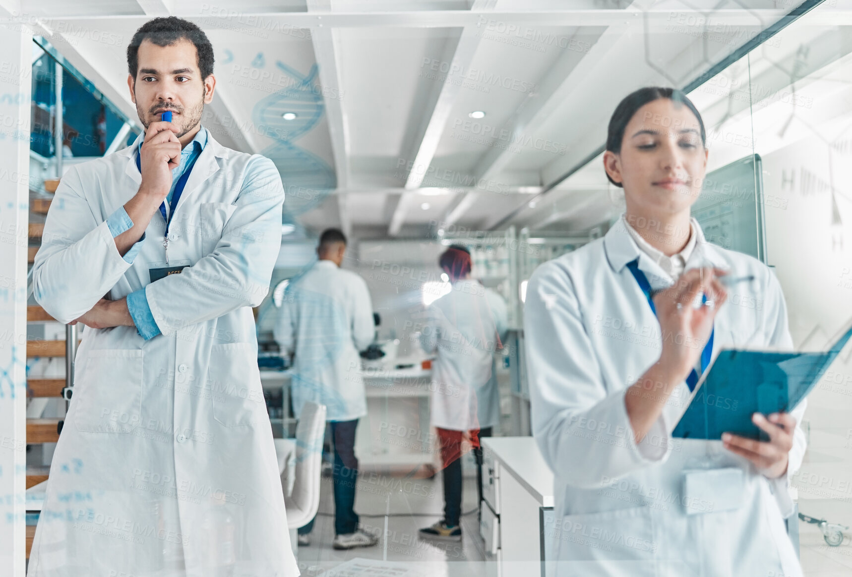 Buy stock photo Shot of two young scientists brainstorming with notes on a glass screen in a lab