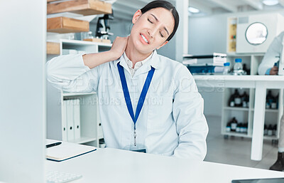 Buy stock photo Shot of a young scientist experiencing neck pain while working in a lab