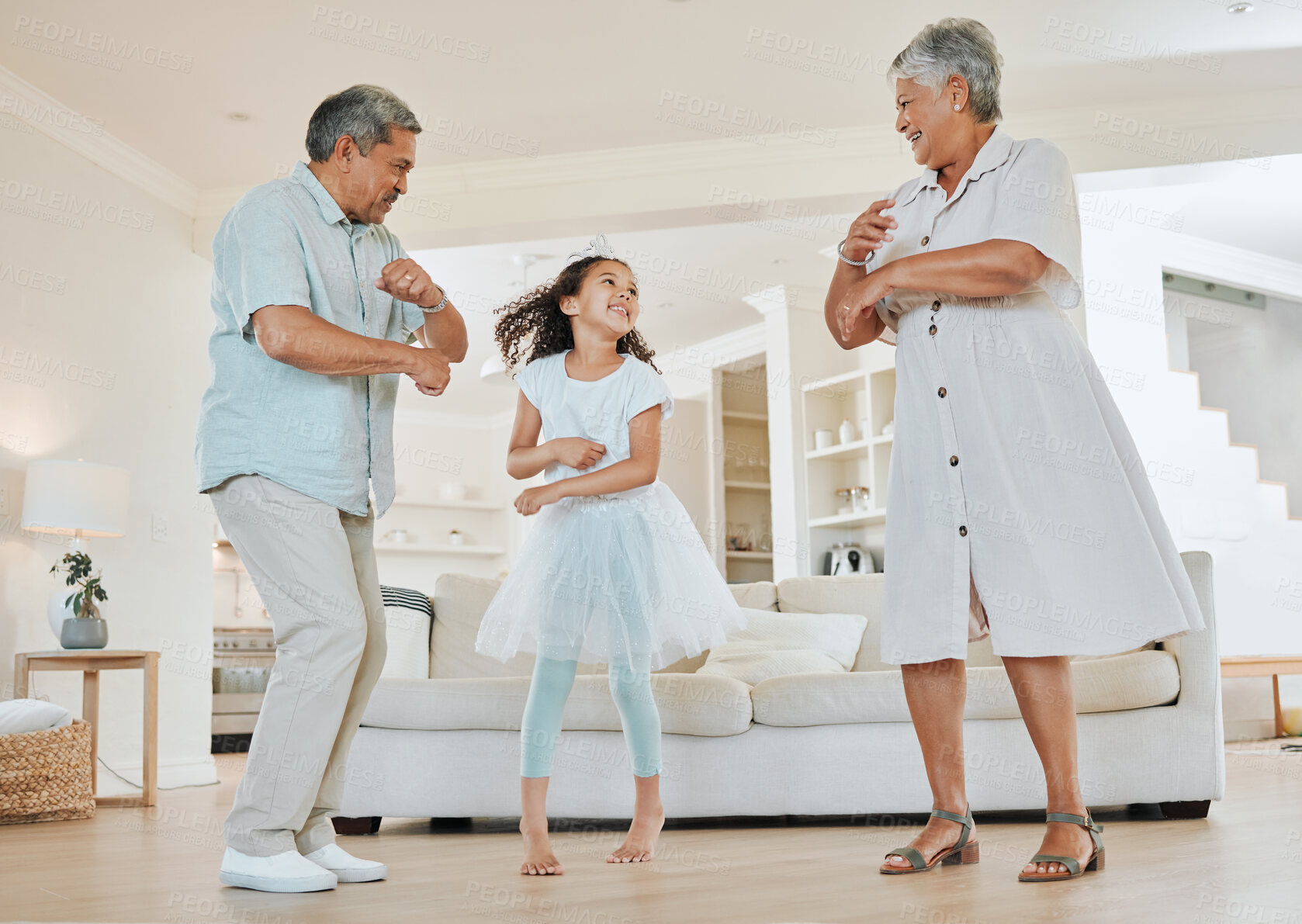 Buy stock photo Shot of grandparents dancing with their granddaughter at home