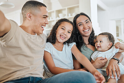 Buy stock photo Shot of a beautiful family taking a selfie together while bonding on the sofa at home