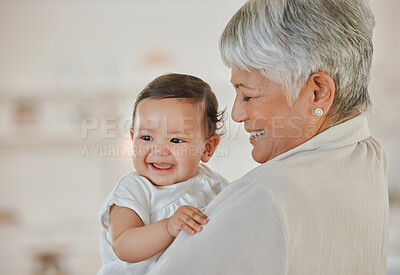 Buy stock photo Shot of a mature woman holding her grandchild at home