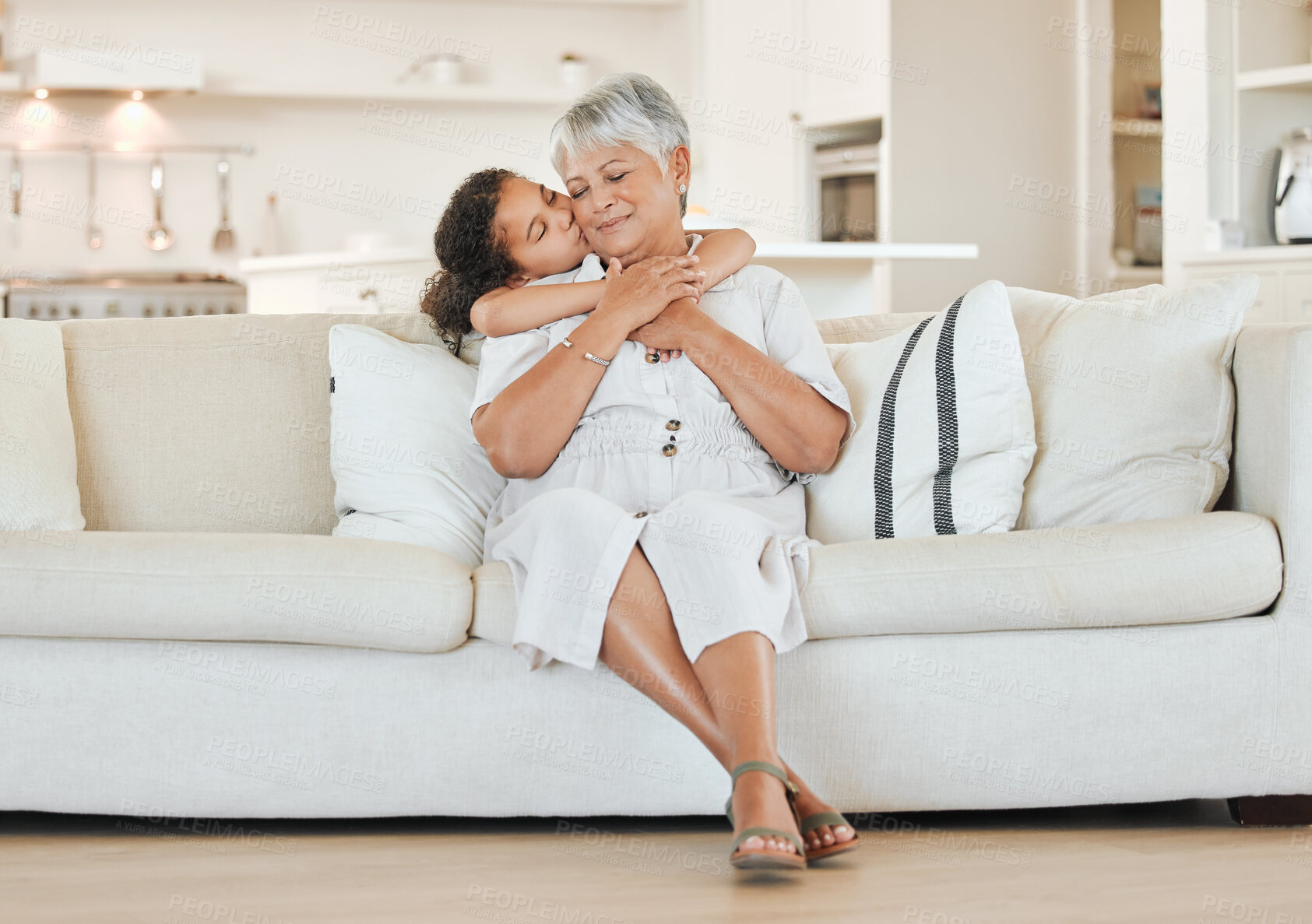 Buy stock photo Love, grandma and grandchild with kiss on sofa with hugging, weekend visit and bonding in house. Happy family, senior woman and girl kid with embrace on couch in living room with support and care