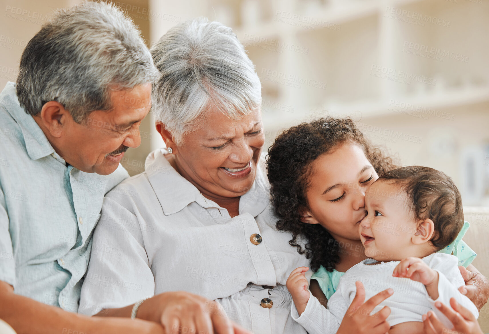 Buy stock photo Grandparents, children and bonding on sofa with smile, embrace and kiss in living room together. Girl, baby and elderly people relax on couch with happy family, fun and support in home in Mexico