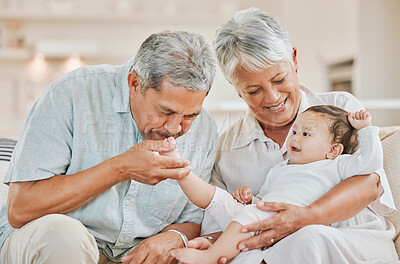 Buy stock photo Shot of grandparents bonding with their grandchild on a sofa at home