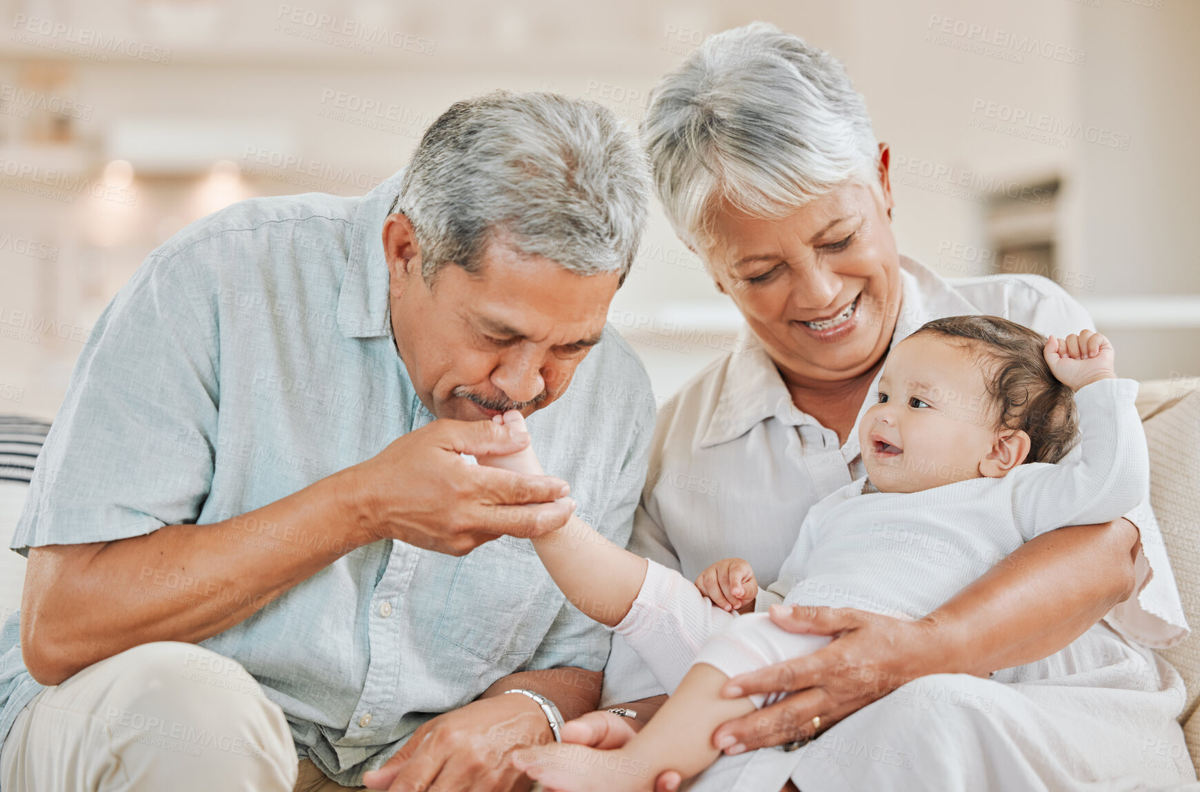 Buy stock photo Love, grandparents and baby on sofa in home with kissing, playing and bonding with smile in living room. Happy family, senior people and grandchild in house with care, support and security for visit