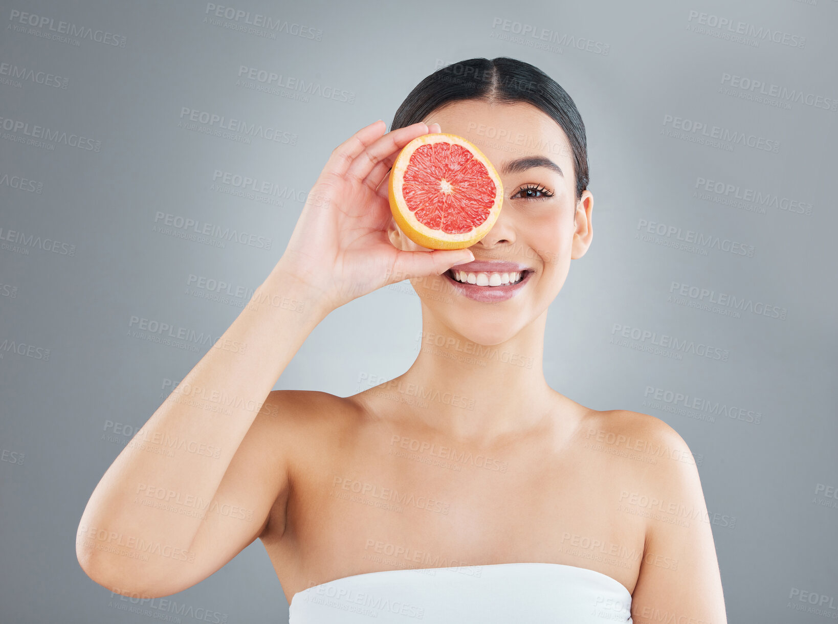 Buy stock photo Grapefruit, happy woman and portrait in studio with skincare for facial routine, exfoliate or glowing skin on gray background. Wellness, fruit and model for vitamin C, dermatology or organic cosmetic