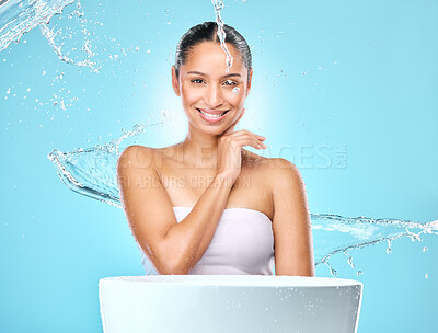 Buy stock photo Portrait, happy model and woman with water, skincare and hygiene for wellness and routine by basin. Face, stream splash and washing for health hydration, smile by studio blue background and cleaning