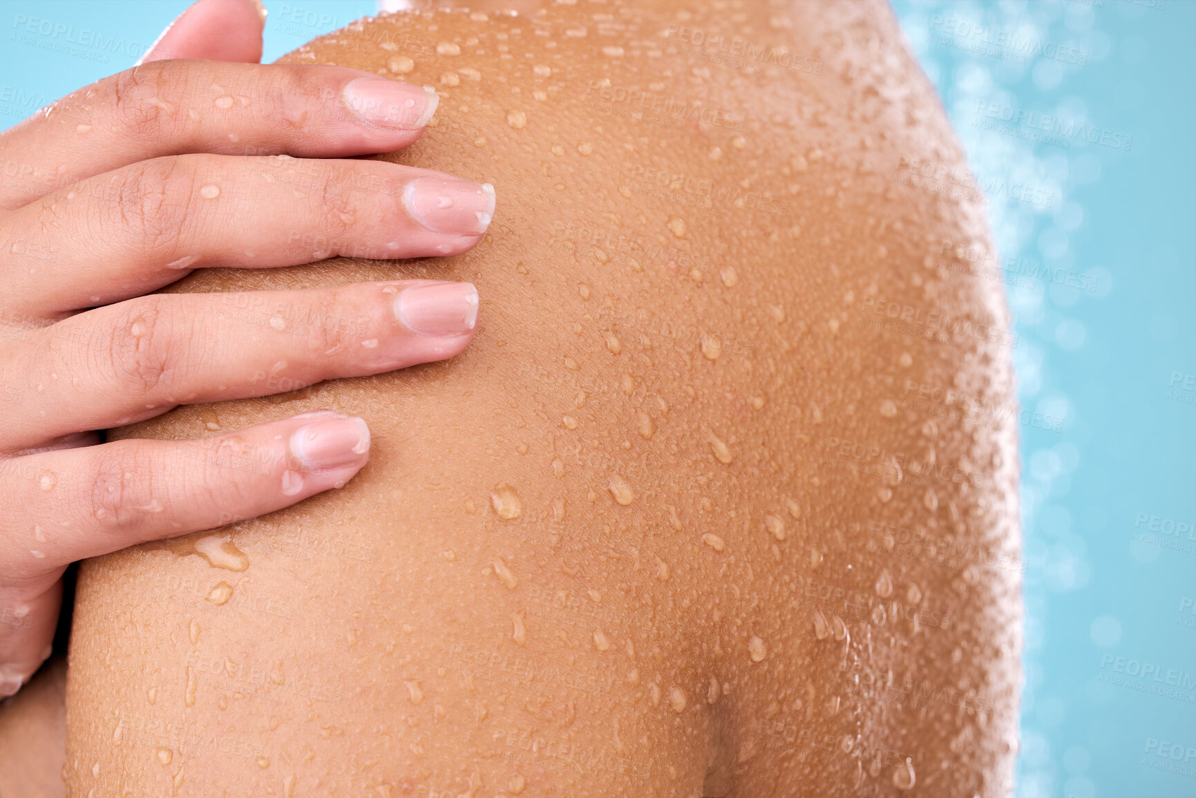 Buy stock photo Hand, woman and shower while cleaning shoulder in studio with female, washing and beauty. Water, model and wellness of a young person in bathroom for self care and dermatology by blue background