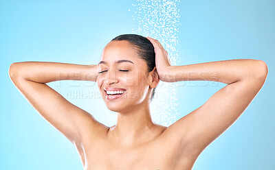 Buy stock photo Shot of a beautiful young woman taking a shower against a blue background