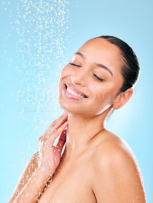 Buy stock photo Shot of a beautiful young woman taking a shower against a blue background