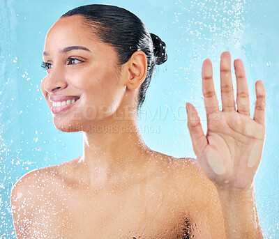 Buy stock photo Shot of a beautiful young woman taking a shower against a blue background