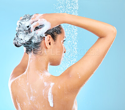 Buy stock photo Cropped shot of a woman washing her hair while taking a shower against a blue background