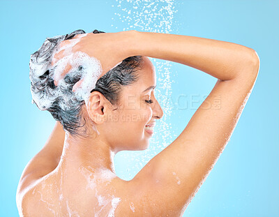 Buy stock photo Cropped shot of a woman washing her hair while taking a shower against a blue background