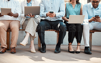 Buy stock photo Cropped shot of an unrecognisable group of businesspeople sitting outside together and using technology
