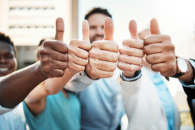Buy stock photo Shot of an unrecognisable group of businesspeople standing outside together and showing a thumbs up