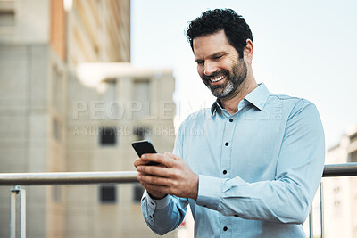 Buy stock photo Shot of a handsome mature businessman standing alone outside and using his cellphone