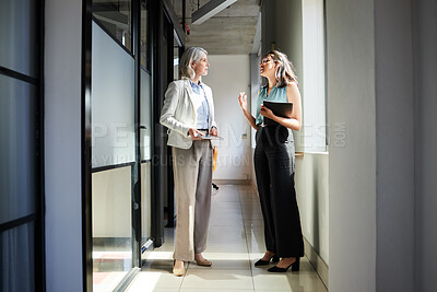 Buy stock photo Full length shot of two businesswomen standing in the office together and having a discussion